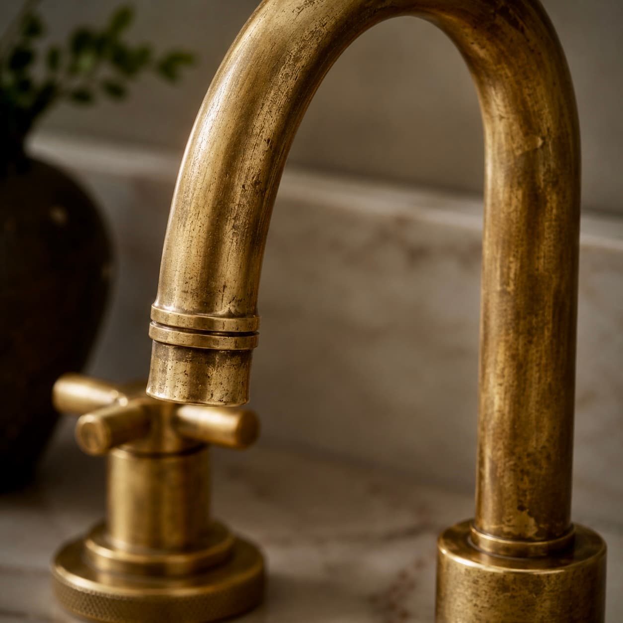 Brass — an aged, living-finish brass faucet on marble