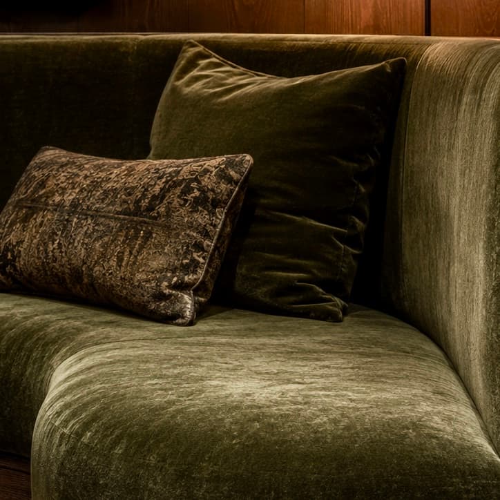 Velvet — a moss green velvet sofa with layered pillows